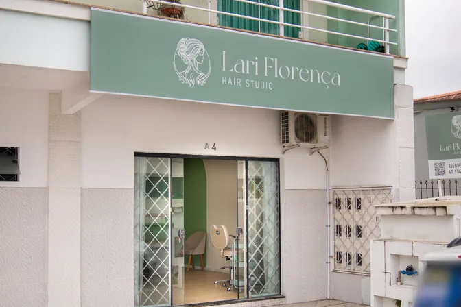Fachada do studio: placa com o nome Lari Florença Hair Studio sobre a entrada de vidro da sala A 4