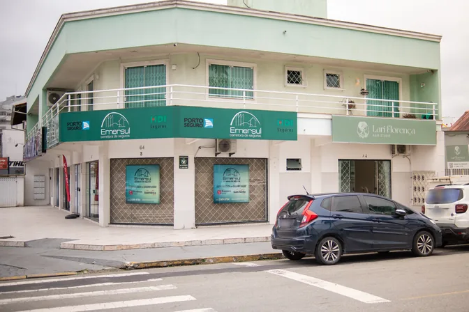 O prédio de esquina onde fica o studio, visto da avenida, com a placa do salão no térreo